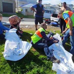 Die twee drenkelinge word hier gestabiliseer. Vlnr: Chantell Buys en Cassie Carstens van Overstrand Medical Response. Jean le Roux en Deon Langenhoven van NSRI Hermanus met Rory Richards wat die 2 drenkelinge uit die see gered het, regs agter.